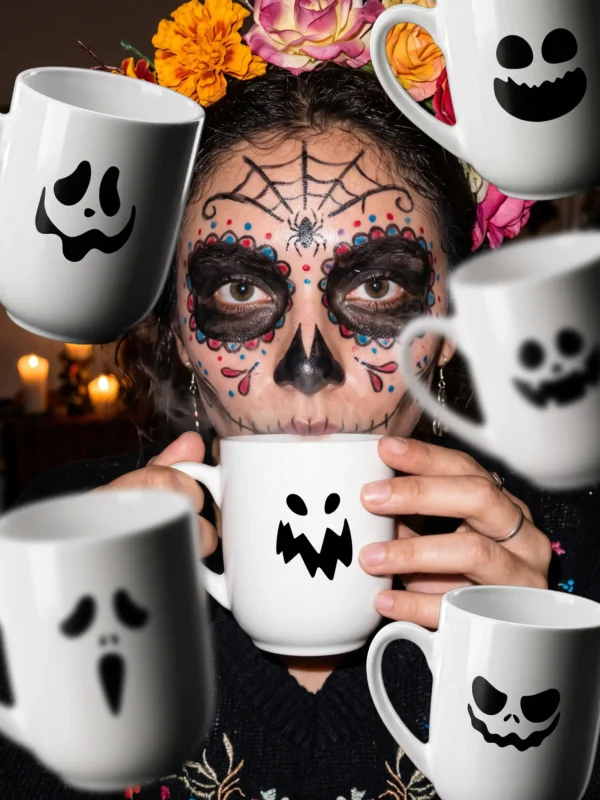 Zestaw trzech białych ceramicznych kubków z halloweenowej serii z nadrukami demonicznych uśmiechów
